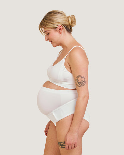 Gravid kvinde med Carriwell støttebælte i hvid set fra siden